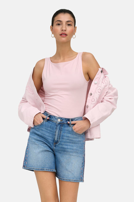 Haut sans manches rose de ONLY®, stylisé avec un short en jean et une veste rose à détails ajourés.