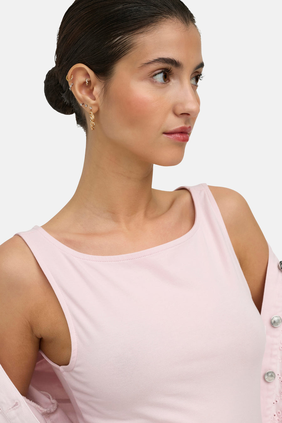 Haut sans manches rose de ONLY® avec col large, stylisé avec des boucles d'oreilles dorées, en gros plan.