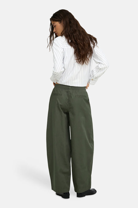 Olijfgroene wijde broek van JDY, achterzijde met elastische taille en zakken, model in gestreept overhemd en zwarte schoenen