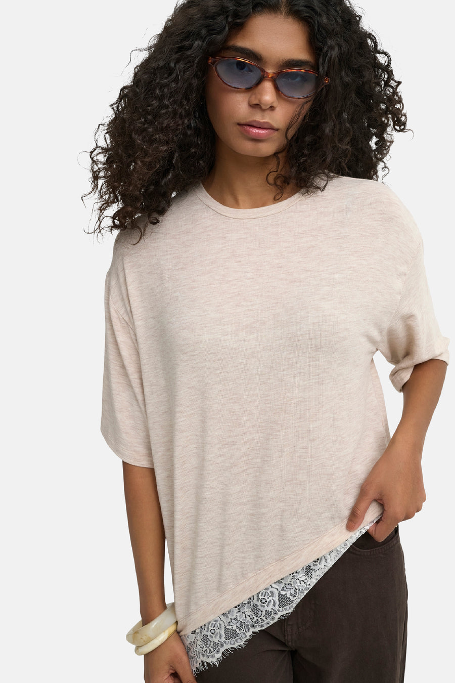Oatmeal korte mouw T-shirt van ONLY® met kantzoom, losse pasvorm, model in zijaanzicht met zonnebril