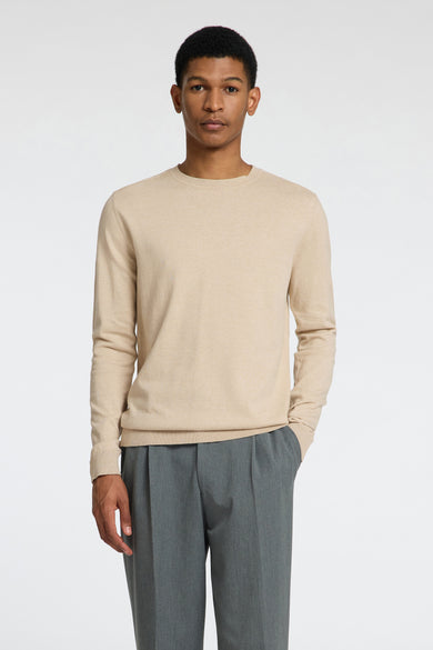 Pull beige avec col rond de SELECTED, avec des manches longues et associé à un pantalon gris et des chaussures marron.