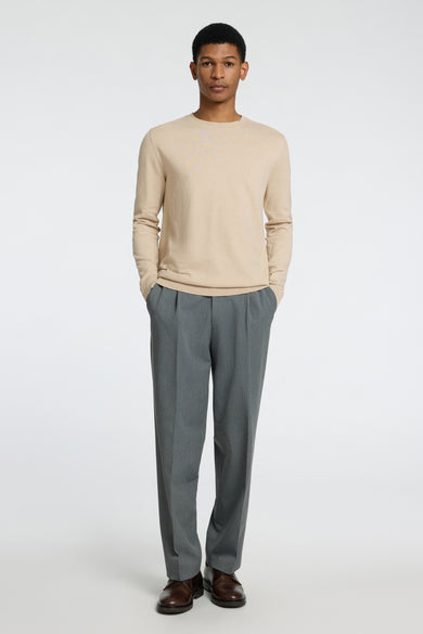 Beige trui met ronde hals van SELECTED, met lange mouwen en gecombineerd met grijze pantalon en bruine schoenen.
