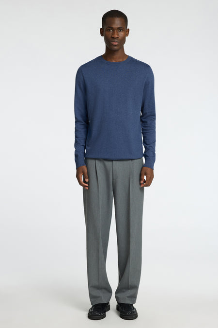 Blauwe trui met ronde hals van SELECTED, gecombineerd met een grijze pantalon en zwarte schoenen.