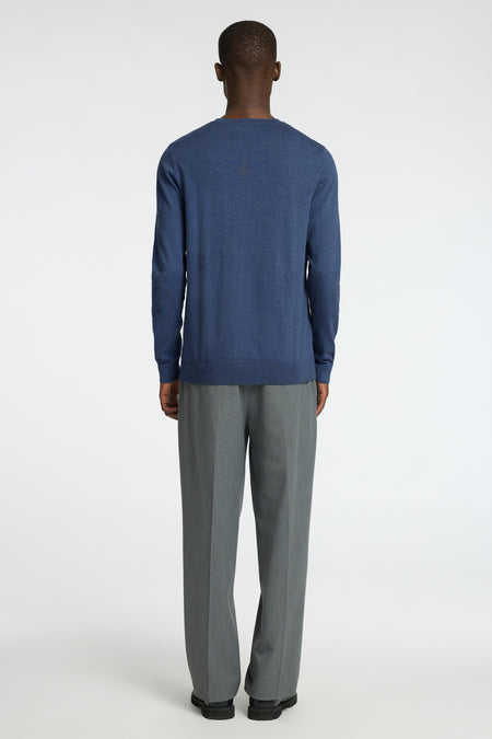 Blauwe ronde-halstrui van SELECTED, gezien van achteren, gecombineerd met grijze pantalon en zwarte schoenen.
