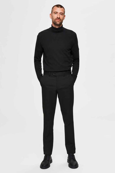 Zwarte coltrui van SELECTED, gladde stof, gedragen door een man met zwarte broek.