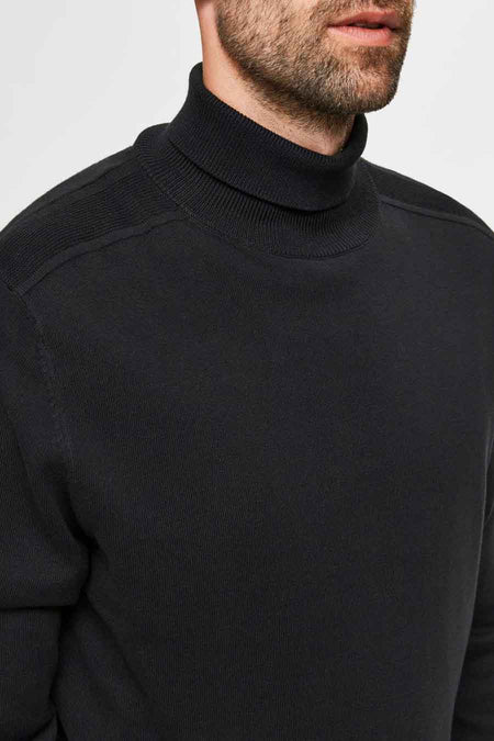 Pull à col roulé noir à maille fine de SELECTED, avec des détails côtelés frappants sur les épaules, porté par un homme.