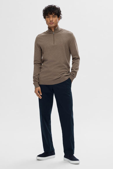 Pull marron avec col rond de SELECTED, porté avec un pantalon bleu marine et des chaussures en cuir suédé avec des semelles blanches.