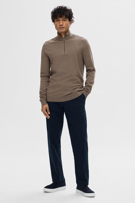 Pull marron avec col rond de SELECTED, porté avec un pantalon bleu marine et des chaussures en cuir suédé avec des semelles blanches.