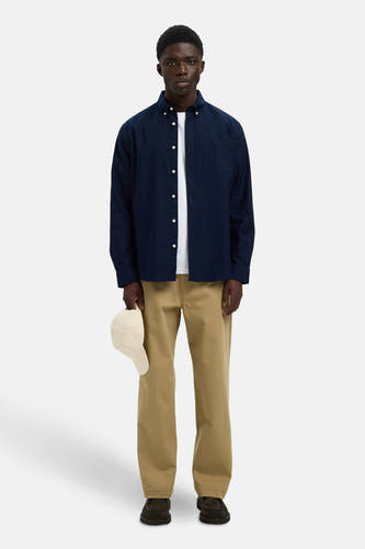 Chemise bleue à manches longues de SELECTED, avec col boutonné, portée sur un T-shirt blanc et un pantalon kaki.
