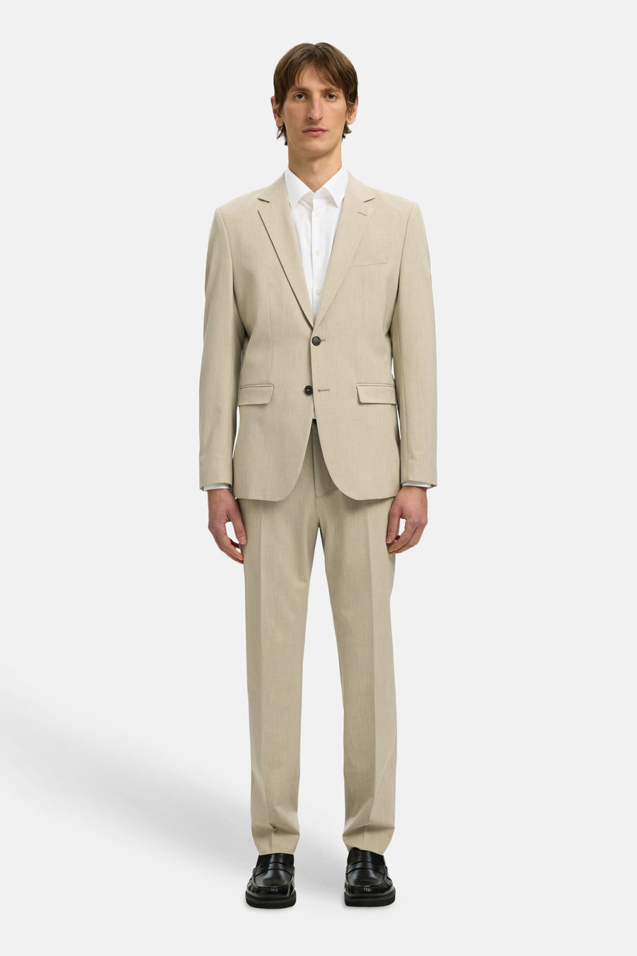 Chemise blanche à manches longues de SELECTED, portée sous un costume beige avec des chaussures noires.