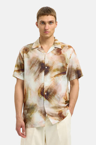 Bruin overhemd met korte mouwen van SELECTED, met een abstract penseelstreekpatroon en gedragen met een crèmekleurige broek.

