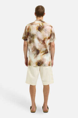 Bruin overhemd met korte mouwen van SELECTED, met een abstract patroon, gedragen met beige shorts en sandalen.
