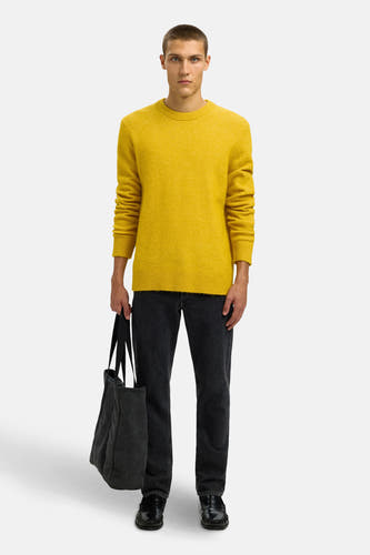 Sweat-shirt bleu avec col rond de SELECTED, porté avec des jeans foncés et une sacoche noire.