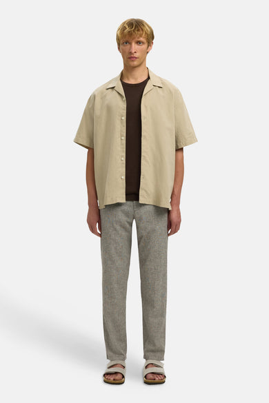 Bruine broek van SELECTED, met een fijne textuur en een losse pasvorm, gecombineerd met een bruin T-shirt en sandalen.