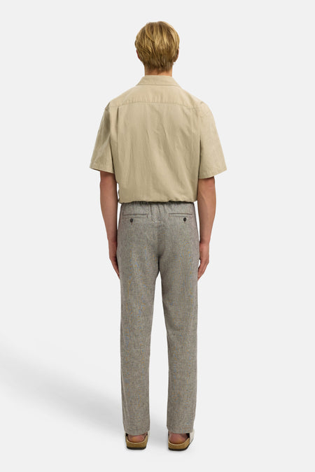 Bruine broek van SELECTED, met een subtiel patroon en achterzakken, gezien van achteren.