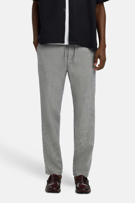 Blauwe broek van SELECTED met subtiele textuur, gecombineerd met een zwart overhemd en bordeauxrode loafers.