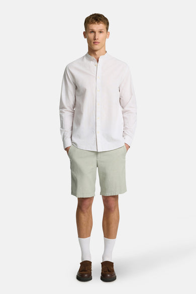 Groene short van SELECTED, gecombineerd met een wit overhemd, witte sokken en bruine schoenen.
