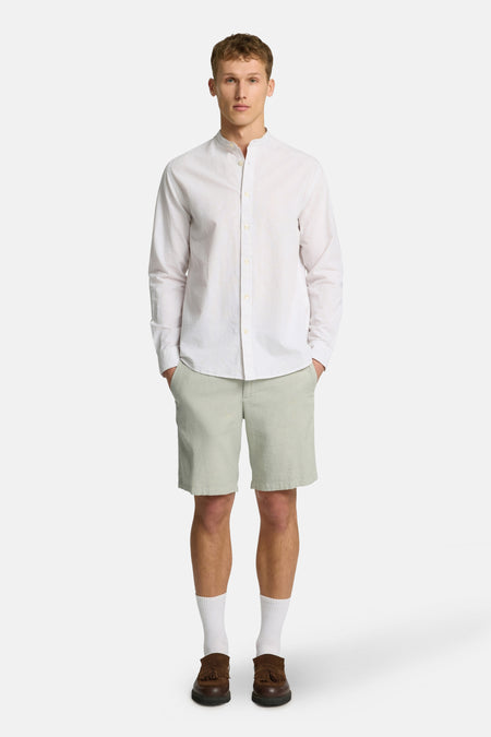 Groene short van SELECTED, gecombineerd met een wit overhemd, witte sokken en bruine schoenen.
