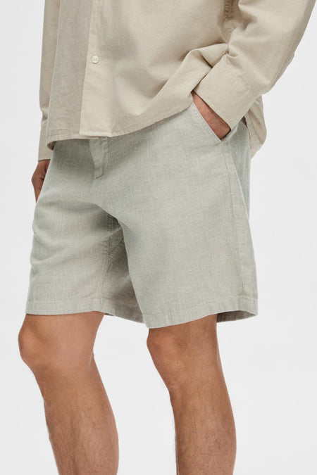 Groene short van SELECTED, met een lichte textuur, steekzak en gedragen met een beige overhemd.