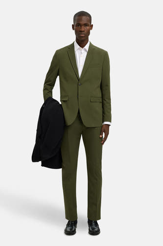 Groene blazer van SELECTED, met een wit overhemd en een zwarte jas erbij.
