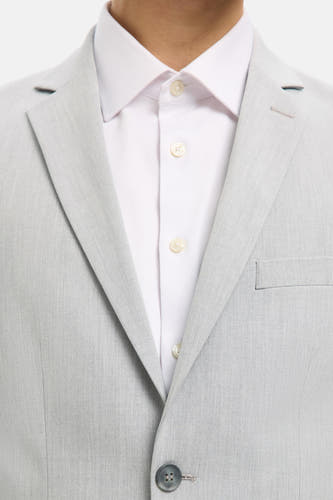 Grijs blazer van SELECTED, met een witte overhemd eronder en een enkele knoopsluiting.