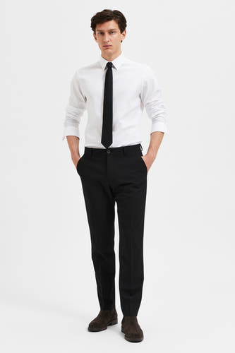 Pantalon de costume noir de SELECTED, porté avec une chemise blanche et une cravate sombre.
