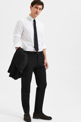 Pantalon de costume noir de SELECTED, porté avec une chemise blanche et une cravate noire.