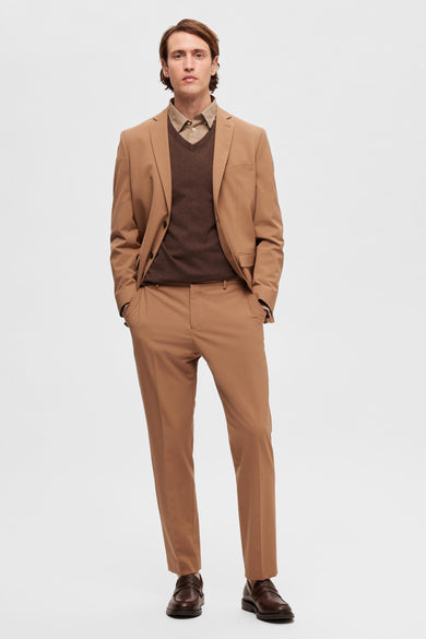 Bruine kostuumbroek van SELECTED, gedragen met een bruin vest en een beige overhemd, gecombineerd met donkerbruine schoenen.
