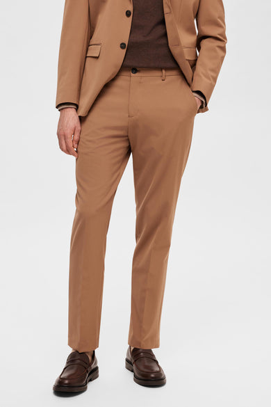 Bruine kostuumbroek van SELECTED, gecombineerd met een bruine trui en bruine leren loafers.
