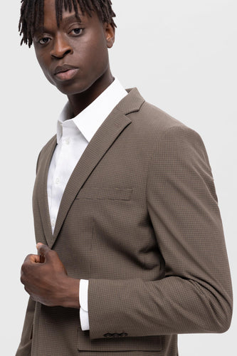 Bruine blazer van SELECTED, met ruitpatroon en gedragen over een wit overhemd.