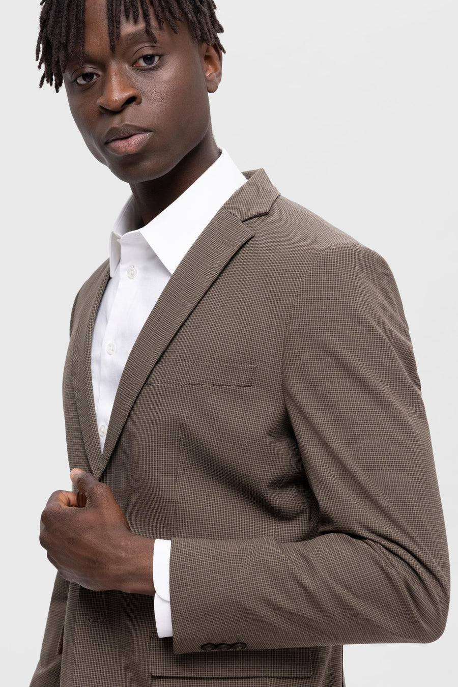 Bruine blazer van SELECTED, met ruitpatroon en gedragen over een wit overhemd.