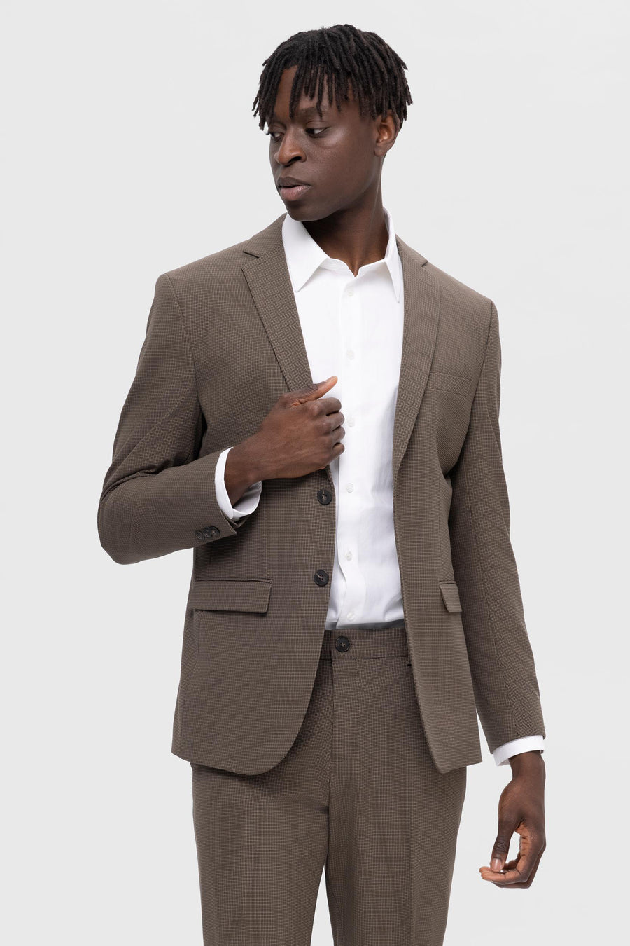 Bruine blazer van SELECTED, met een fijn ruitpatroon, gedragen over een wit overhemd.
