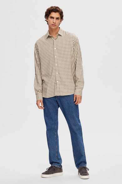 Bruin overhemd met lange mouwen van SELECTED, met een ruitpatroon, gedragen met een blauwe jeans en suède schoenen.
