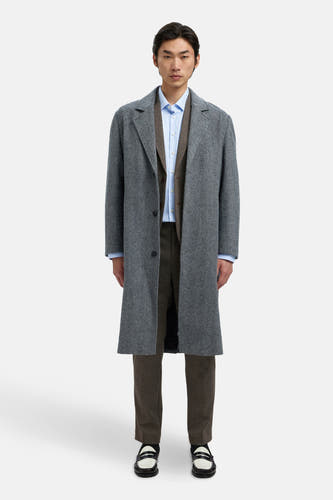 Bruine blazer van SELECTED, met blauw overhemd en grijze jas, gecombineerd met bruine pantalon en zwart-witte loafers.