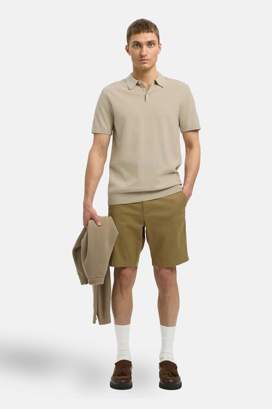 Beige polo met korte mouwen van SELECTED, gedragen met kaki shorts, witte sokken en bruine loafers.
