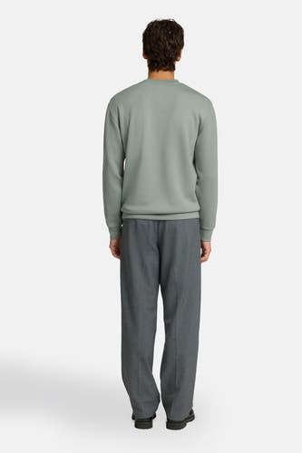 Groene sweater met ronde hals van SELECTED, gedragen door een man, rugaanzicht, gecombineerd met een grijze broek.
