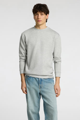 Pull gris de SELECTED, porté avec un jean, sur fond blanc.