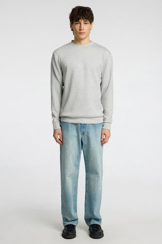 Pull gris de SELECTED, porté avec un jean bleu et des chaussures noires.