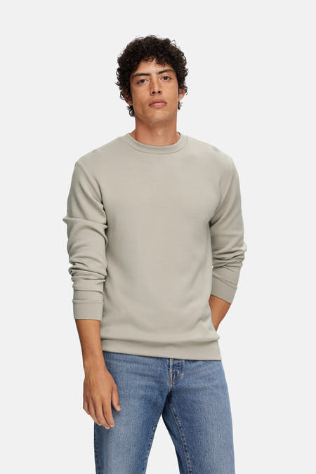 Ecru sweater van SELECTED, gedragen met blauwe jeans.
