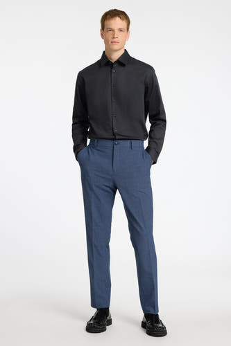 Chemise noire à manches longues de SELECTED, portée avec un pantalon bleu et des chaussures noires.