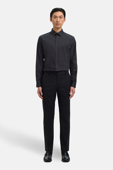Chemise noire à manches longues de SELECTED, portée avec un pantalon noir et des chaussures en cuir.