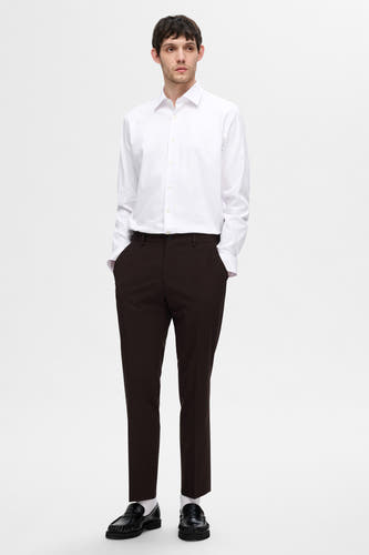 Wit overhemd met lange mouwen van SELECTED, gedragen met bruine pantalon en zwarte schoenen met witte sokken.
