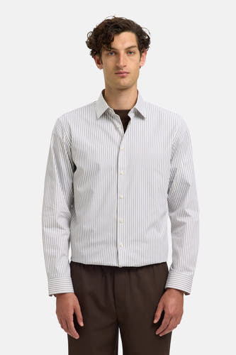 Chemise à rayures blanches et noires (manches longues) de SELECTED, avec un pantalon marron en dessous.