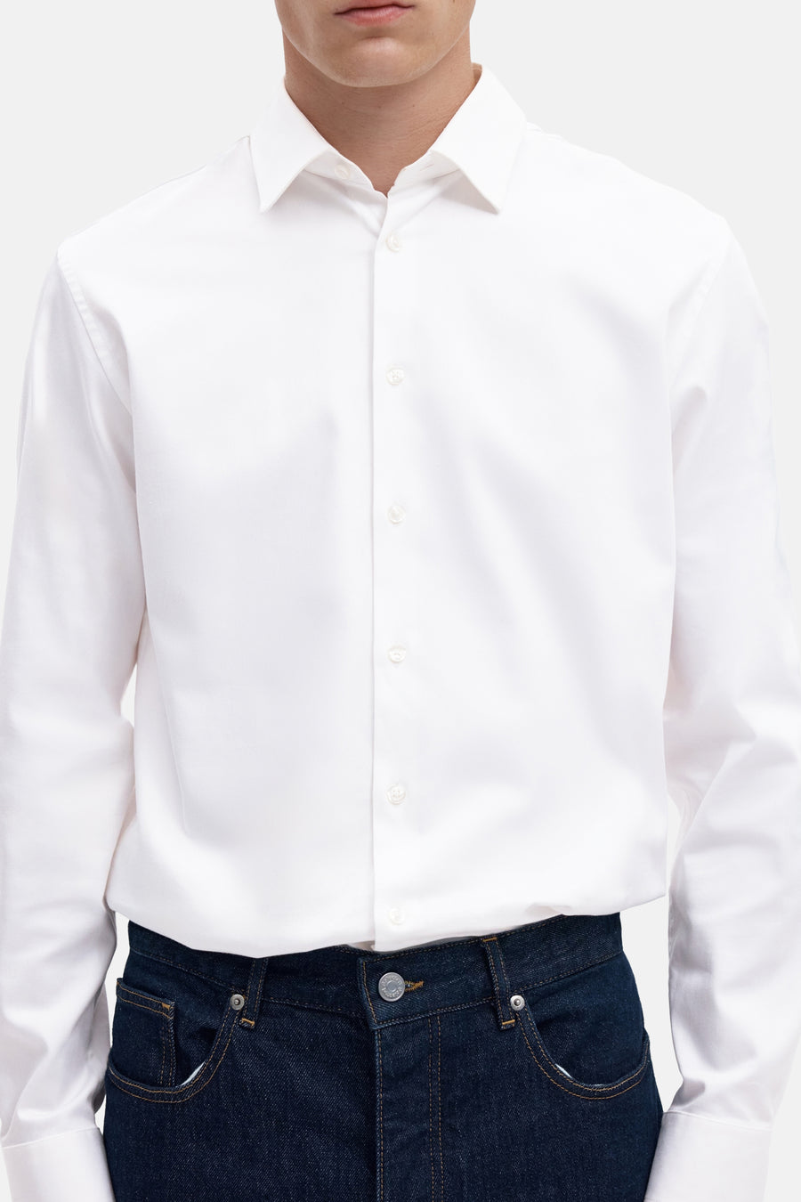 Wit overhemd met lange mouwen van SELECTED, gestikt, klassieke kraag, knoopsluiting, gedragen met donkerblauwe jeans, close-up vooraanzicht