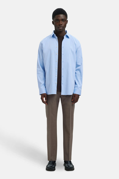 Blauw, lange mouwen overhemd van SELECTED, gedragen met een bruine trui en bruine pantalon.
