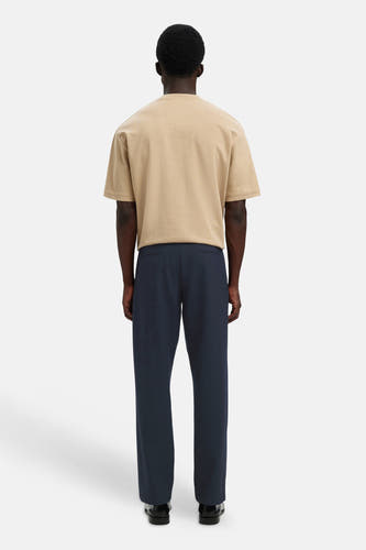 Blauwe broek van SELECTED, achterkant, rechte pasvorm, gladde stof, model draagt beige t-shirt en zwarte schoenen