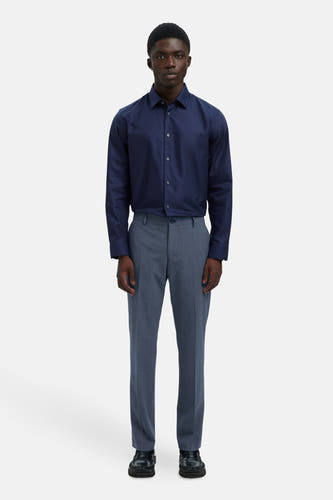 Blauwe kostuumbroek van SELECTED, gecombineerd met een donkerblauw overhemd en zwarte schoenen.