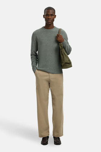 Groene trui met ronde hals van SELECTED, met een fijne textuur, gedragen met kaki broek en een olijfgroene tas.
