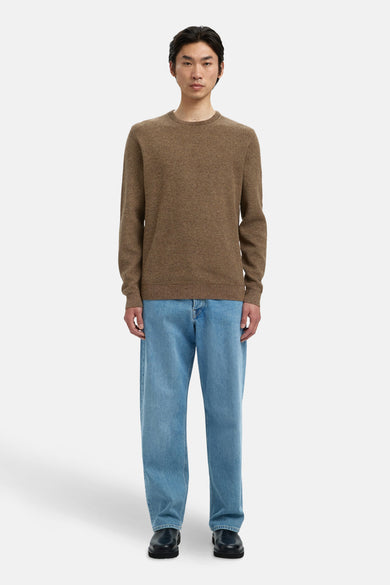 Bruine trui met ronde hals van SELECTED, gedragen met een blauwe jeans en zwarte schoenen.
