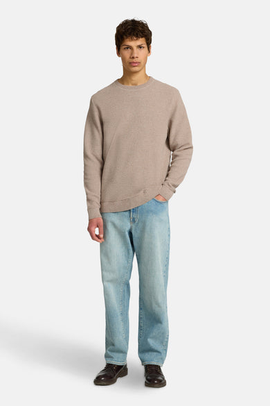 Bruine trui met ronde hals van SELECTED, gedragen met wijde jeans en bruine schoenen.